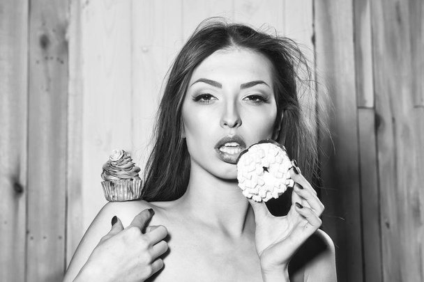 figure or sweets. Woman with cupcake and doughnut - Фото, изображение