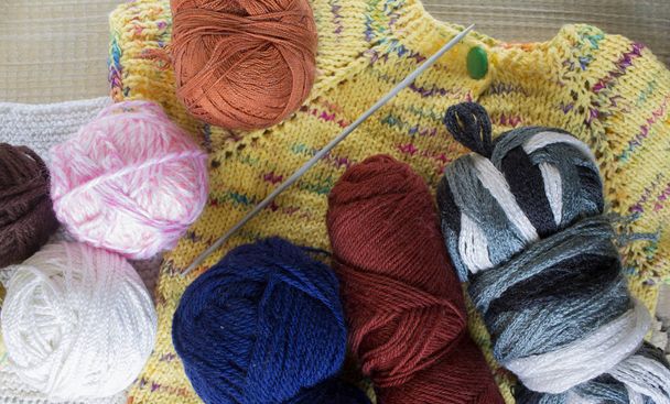 knitting sweater, yarn balls on table - Fotó, kép