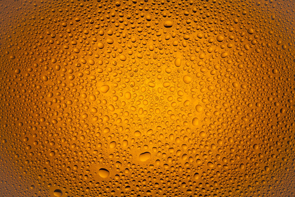 Close-up de uma água cai sobre um fundo gradiente laranja, coberto com gotas de condensação de água
. - Foto, Imagem