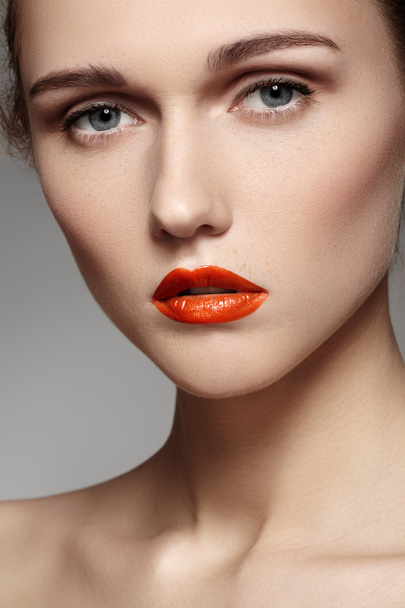 Portret van mooie vrouw zuiverheid gezicht met heldere rode lippen make-up. Schattig model met schone glimmende huid - Foto, afbeelding