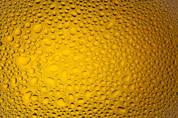 Close-up de uma água cai sobre um fundo gradiente laranja, coberto com gotas de condensação de água
. - Foto, Imagem