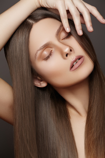 Health, beauty, wellness, haircare, cosmetics and make-up. Beautiful fashion hairstyle. Portrait of woman model with shiny straight long hair and natural make-up - Zdjęcie, obraz