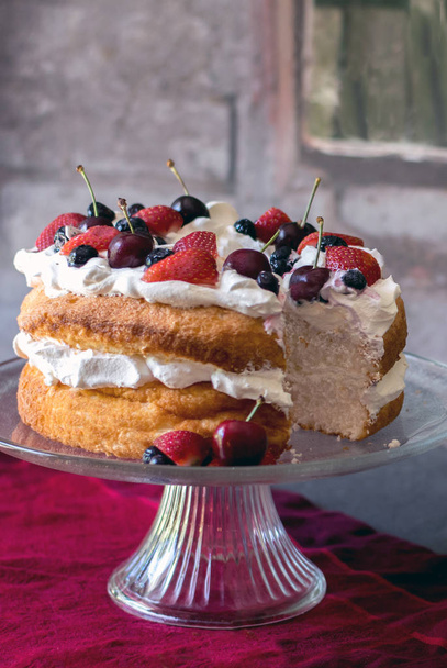 ホイップ クリームと新鮮なカラフルな果実で覆われた美しい angelfood ケーキ - 写真・画像