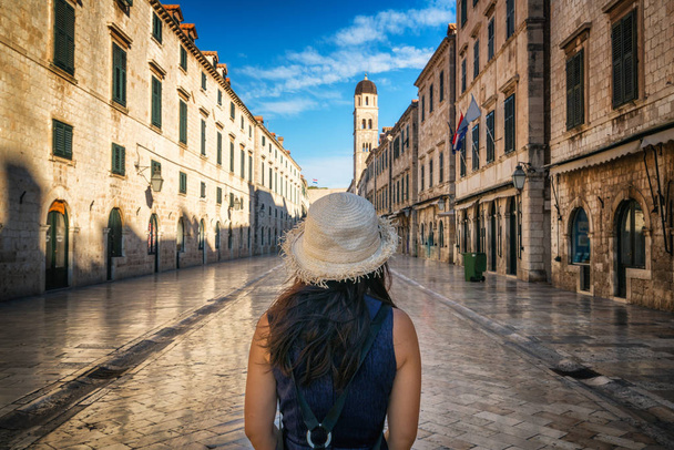 Traveler walks on the historic street of Stradun (Placa) in old town of Dubrovnik in Croatia - Prominent travel destination of Croatia. Dubrovnik old town was listed as UNESCO World Heritage in 1979. - Photo, Image