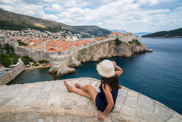 Traveller looking at view of Dubrovnik Old Town, in Dalmatia, Croatia, the prominent travel destination of Croatia. Dubrovnik old town was listed as UNESCO World Heritage Sites in 1979. - Photo, Image