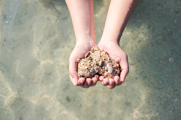 Hände, die einen Sand in Herzform halten, Hände, die Sand in Herzform halten, Hände, die Sand in Herzform halten. Hände eines Mädchens, das Sand am Strand trägt. Frau macht ein Herz aus Sand. Hände, die einen Sand in Herzform halten - Flitterwochen - Foto, Bild