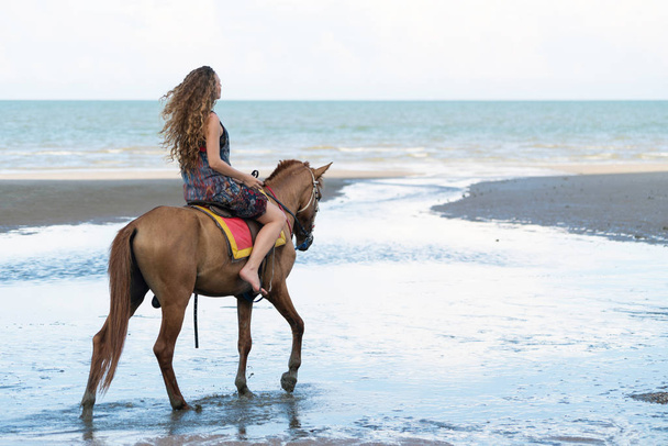 Yaz aylarında sahilde bir binicilik kadın bir modeldir. Lüks seyahat etmek tatil. - Fotoğraf, Görsel