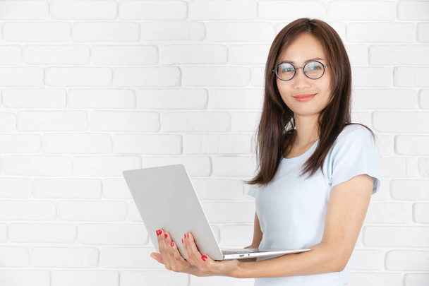 Mulher asiática usando laptop, local de trabalho em casa. Conceito de estilo de vida de mulher asiática
. - Foto, Imagem