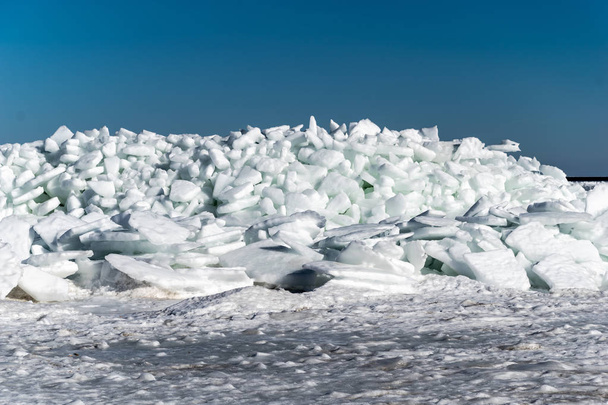 lago congelado cubierto con una pila de témpanos de hielo y cielo azul. latvia, invierno
 - Foto, imagen