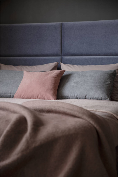 Grey and pink pillow on bed with headboard in woman's bedroom interior - Photo, Image