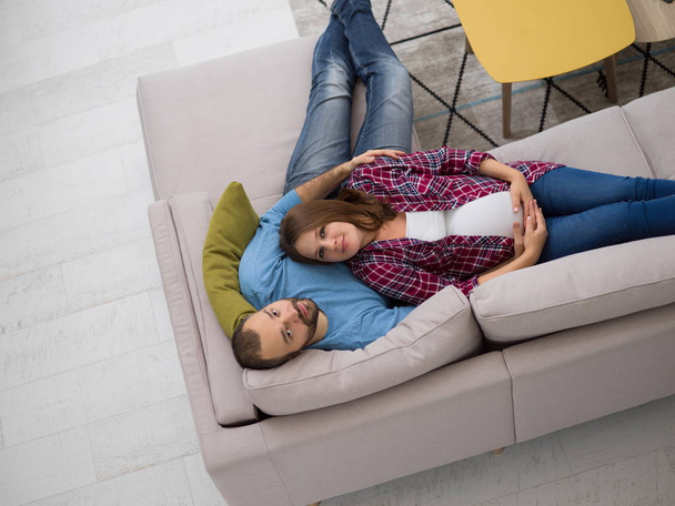 top view of happy pregnant couple relaxing on sofa couch at home - Fotoğraf, Görsel