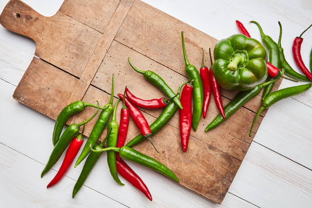 green and red Mexican hot chili peppers on wooden board , flat lay - Foto, Bild