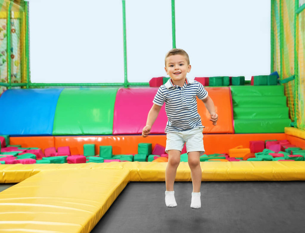 Cute boy jumping on trampoline in entertainment center - Fotoğraf, Görsel