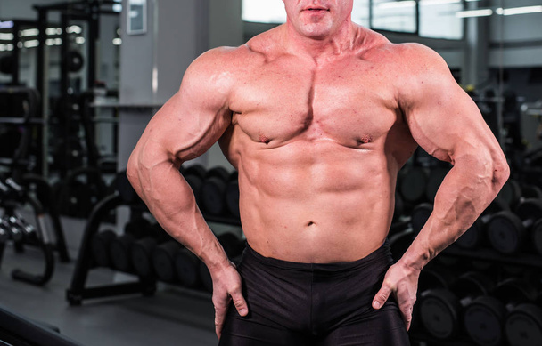 Bodybuilder homme avec des biceps parfaits, triceps et poitrine dans la salle de gym
 - Photo, image