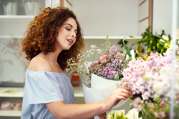 Nice pleasant woman touching flowers - Fotoğraf, Görsel