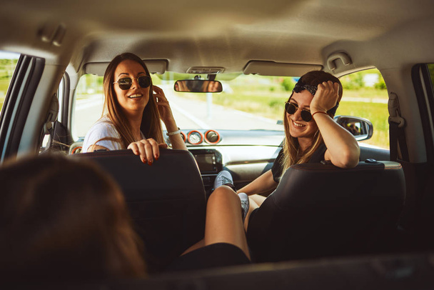 Three women enjoying road trip. They chatting while sitting in the car. - Fotoğraf, Görsel