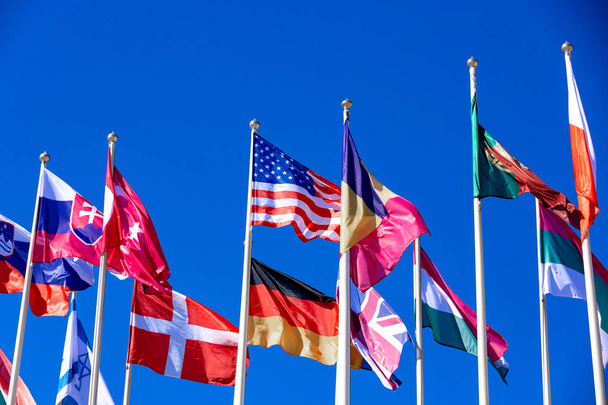 Banderas de diferentes países ondean en el viento contra
 - Foto, Imagen