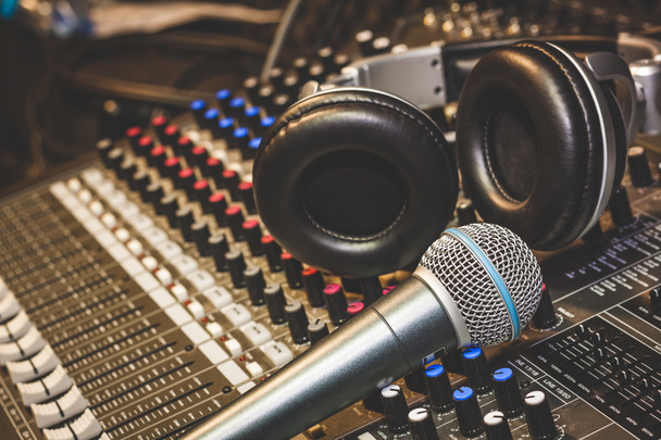 Close up instruments music background concept.Single microphone with headphones on sound mixer board in home recording studio.Free space for creative design text & wording mock up template. - Photo, Image