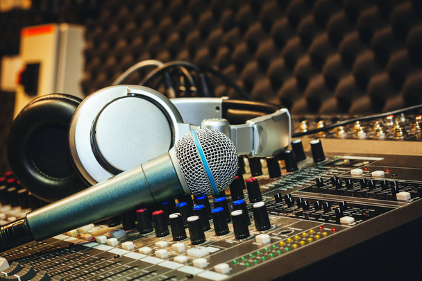 Close up instruments music background concept.Single microphone with headphones on sound mixer board in home recording studio.Free space for creative design text & wording mock up template wallpaper. - Photo, image