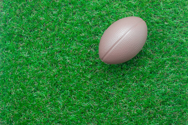 Table top view aerial image soccer or football tournament season background.Flat lay objects brown ball on the artificial green grass wallpaper.Copy space for creative design mock up text and content. - Photo, image
