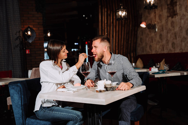 Stylish wealthy couple having desert and wine together in a restaurant. - Valokuva, kuva