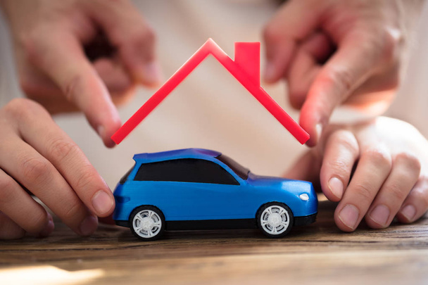 Human Hand Protecting Blue Car With Red Roof - Фото, изображение