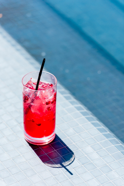 close-up shot of glass of berry cocktail on poolside - Photo, Image