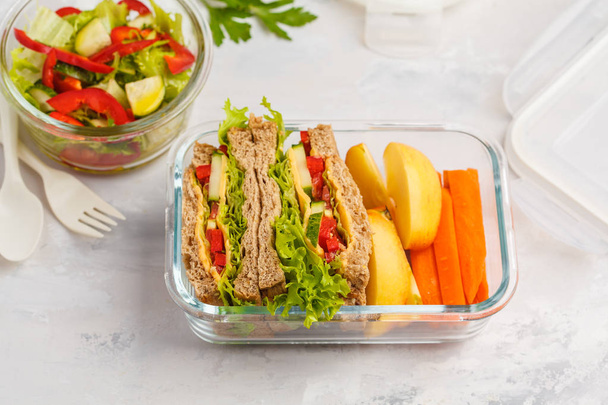 Healthy meal prep glass containers with cheese vegetables sandwiches and vegetable salad overhead shot with copy space - 写真・画像