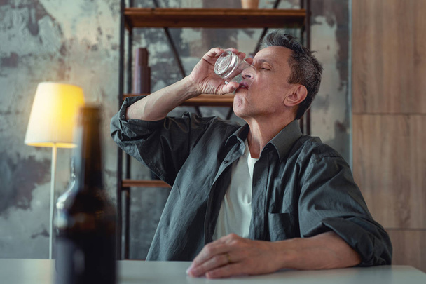 Alcohol addicted man finishing his glass of whisky - Foto, Imagem