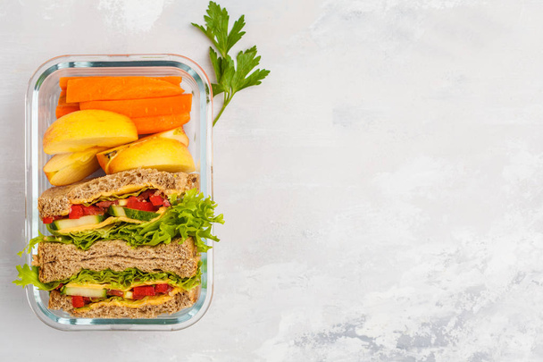 Healthy meal prep glass container with cheese vegetables sandwiches and vegetable salad overhead shot with copy space - Foto, Imagem
