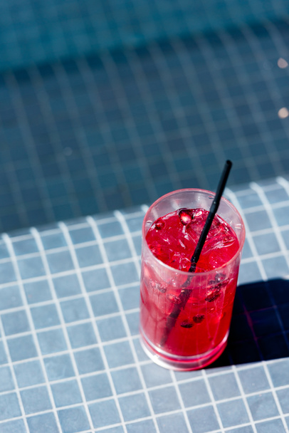 close-up shot of glass of delicious berry cocktail on poolside - Fotoğraf, Görsel