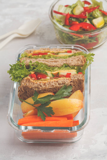 Healthy meal prep glass containers with cheese vegetables sandwiches and vegetable salad overhead shot with copy space - Foto, Imagem