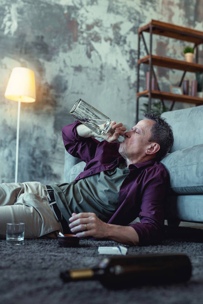 Alcoholic drinking vodka from the bottle - 写真・画像