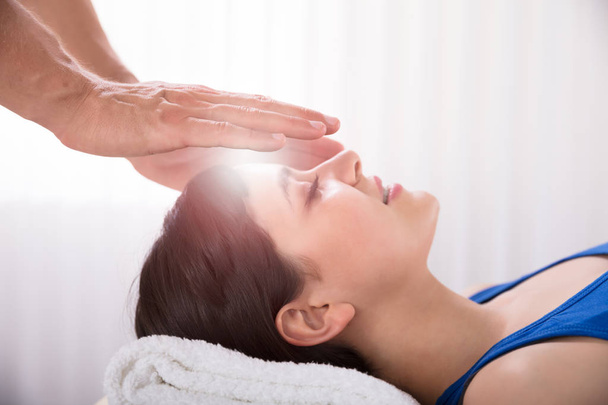 Close-up Of Therapist's Hand Performing Reiki Treatment On Young Woman In Spa - Foto, Imagen