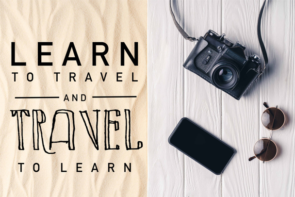 Smartphone con cámara y gafas de sol en el muelle en arena clara con letras "aprender a viajar y viajar para aprender"
 - Foto, Imagen