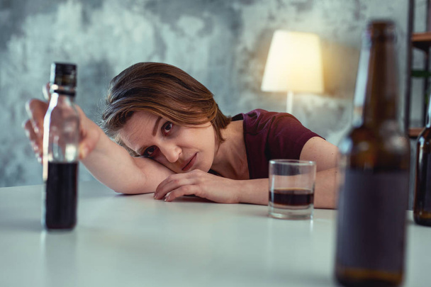 Dark-haired addicted woman taking bottle of whisky - Photo, image