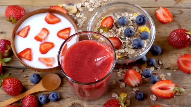 Erdbeere in frischem Smoothie zum Frühstück in Zeitlupe. gesundes Trinken. gesundes Frühstück mit Joghurt und Müsli. - Filmmaterial, Video