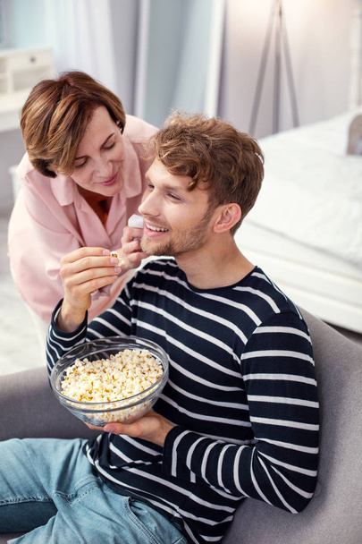 Joyful positive man eating popcorn - Photo, Image
