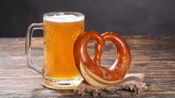 Een glas bier en krakeling op een houten tafel - Video