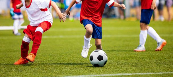Ragazzi che danno calci alla partita di calcio sull'erba. Partita di calcio giovanile. Competizione sportiva per bambini. Bambini che giocano all'aperto
 - Foto, immagini