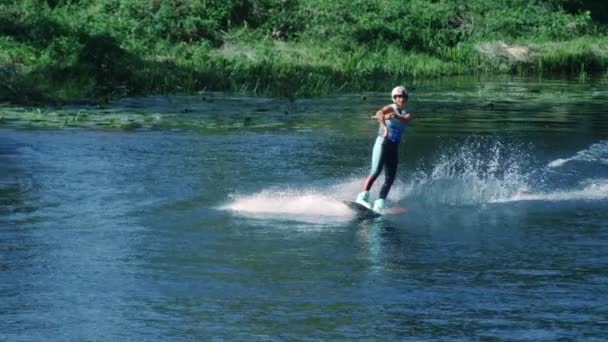 Hezká dívka wakeboarding na letní řeky. Žena cvičí vodní lyžování - Záběry, video