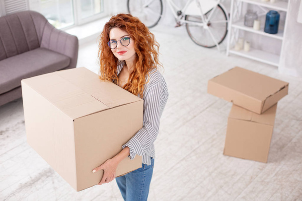 Glad appealing woman preparing for moving out - Фото, изображение