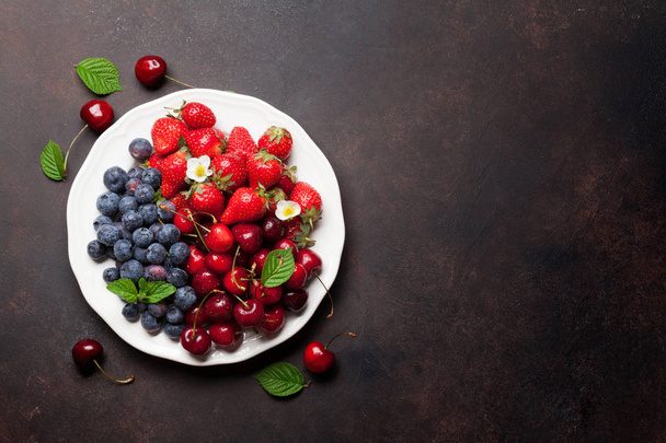 Fresh summer berries. Cherries, blueberries and strawberries in bowl. Top view with space - Фото, зображення