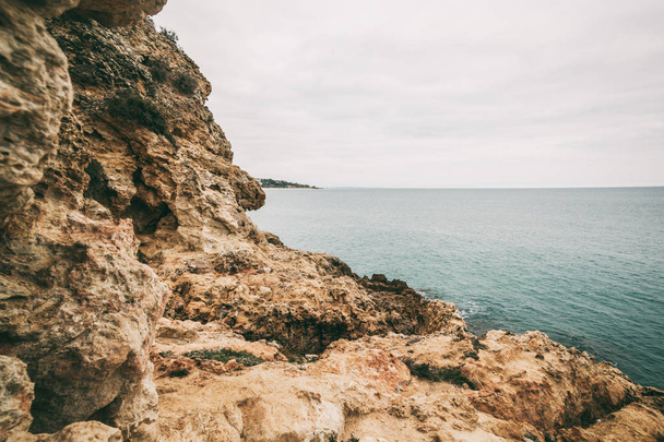Rocks and water surface, Atlantic ocean coast, Portugal, Faro, Algarve, image with retro toning - Fotoğraf, Görsel