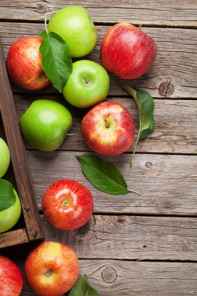 Dojrzałe jabłka zielone i czerwone na drewnianym stole. Widok z góry z miejsca na tekst - Zdjęcie, obraz