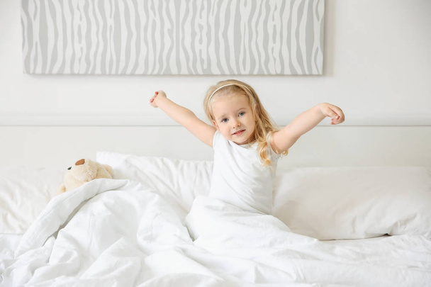 Carino bambina che si estende a letto a casa
 - Foto, immagini