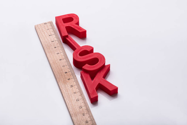 Elevated View Of Red Risk Word And Wooden Ruler On White Background - Фото, изображение