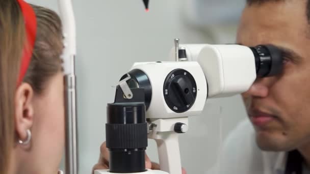 κοντινό πλάνο του το επανδρώνει πρόσωπο διευθύνει βιομικροσκόπηση των ματιών στην κλινική - Πλάνα, βίντεο