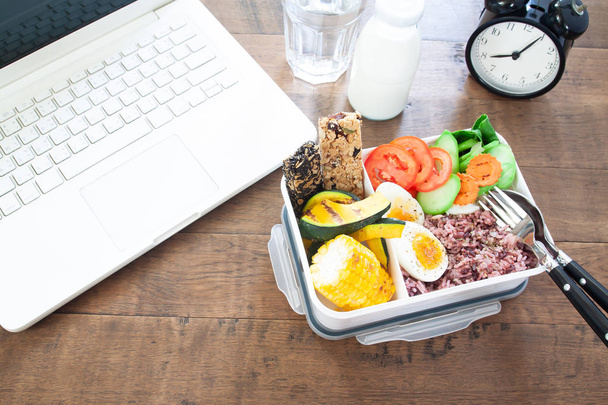 Здоровая коробка для завтрака с рисовыми ягодами, вареными яйцами, морковью, помидорами, кукурузой, тыквой и батончиками, едой и здоровьем
 - Фото, изображение
