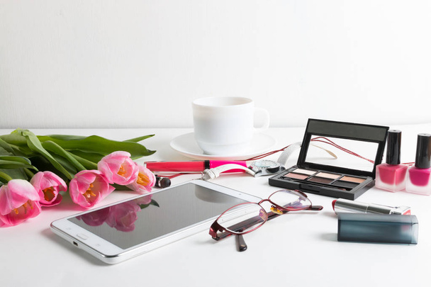 Pink tulips, tablet, cosmetics, wristwatch, notepad, cup of coffee, glasses - spring female things - 写真・画像